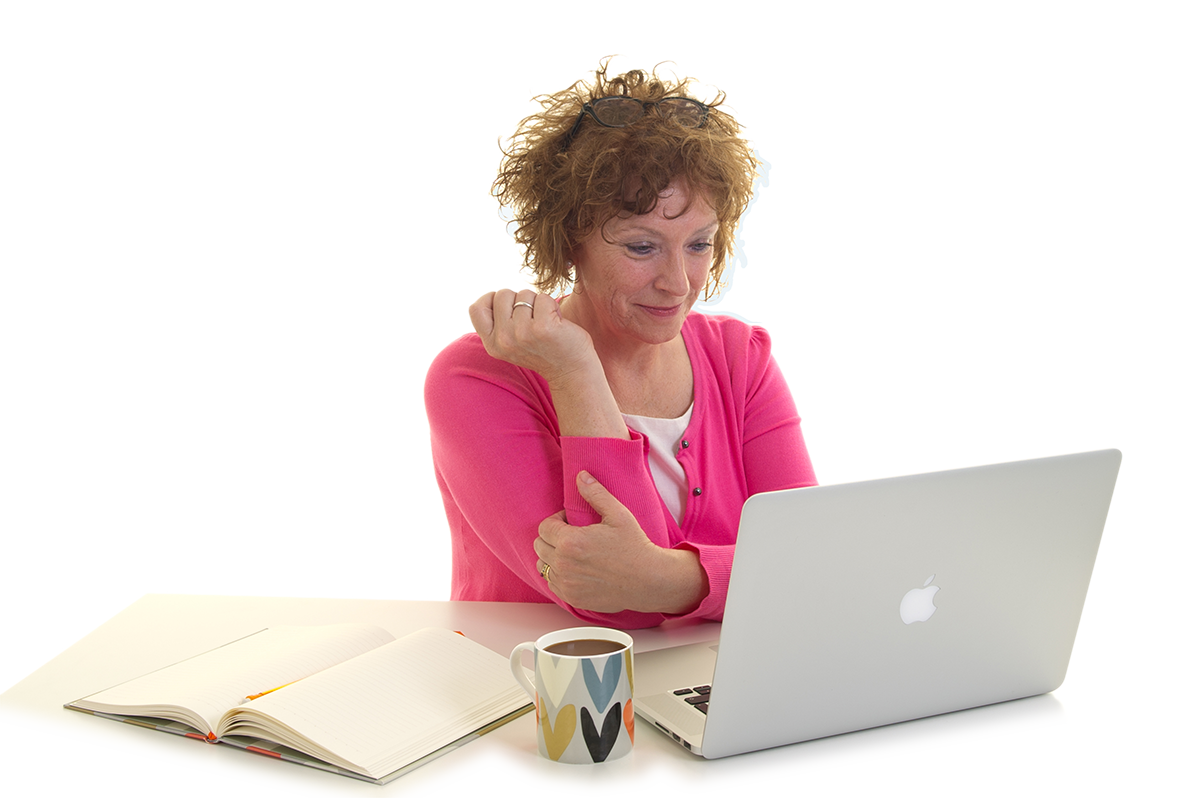 Maureen Bowes smiling, looking at laptop